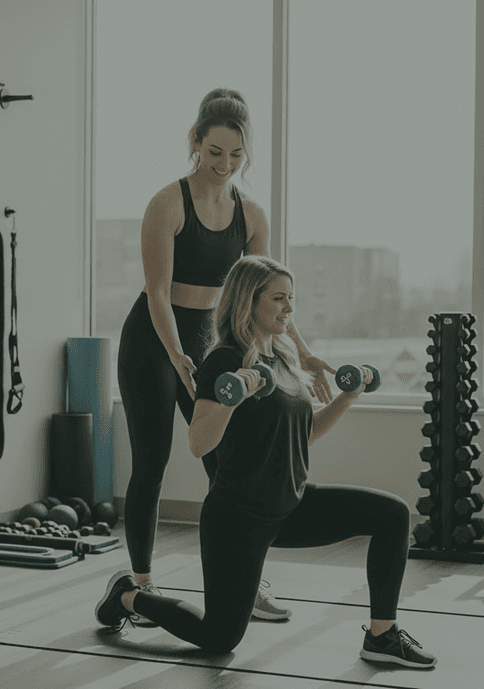 Trainer guiding a client through a dumbbell lunge in a private suite